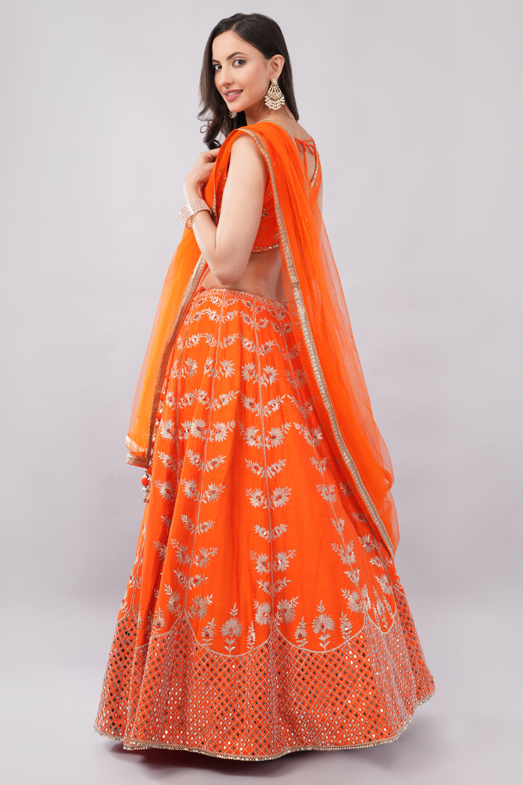 Rust orange raw silk embellished Lehenga choli.
