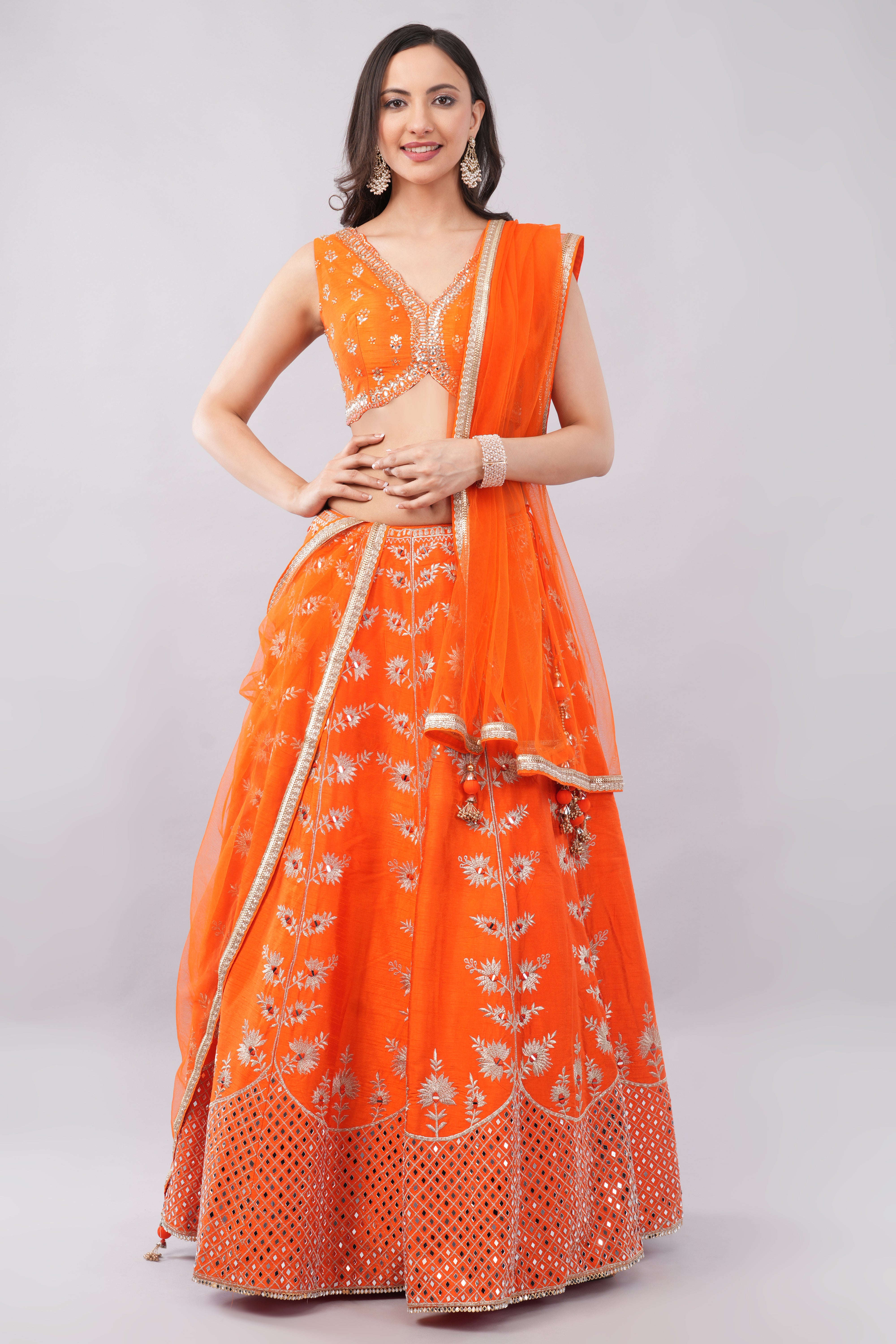 Rust orange raw silk embellished Lehenga choli. Main image