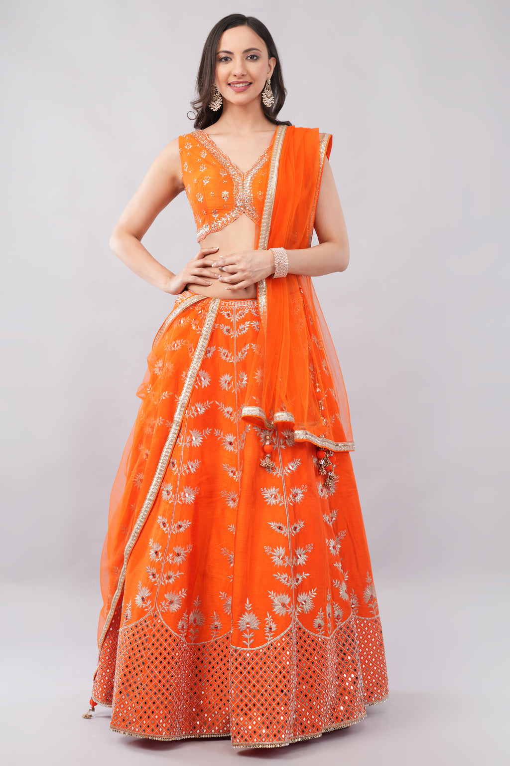 Rust orange raw silk embellished Lehenga choli.