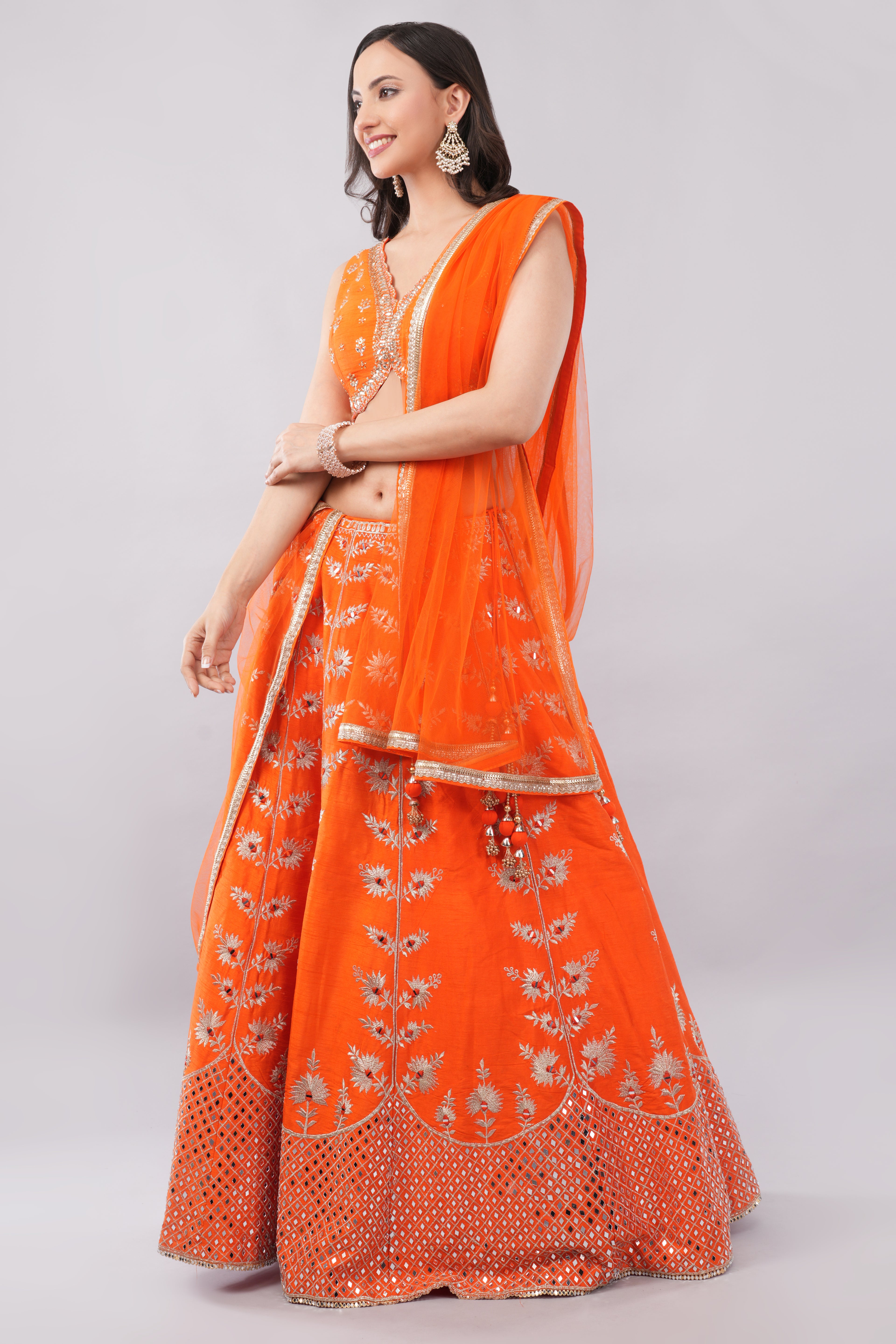Rust orange raw silk embellished Lehenga choli.