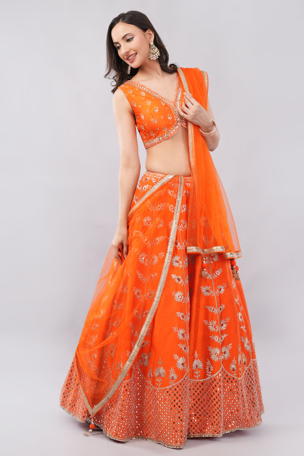 Rust orange raw silk embellished Lehenga choli.