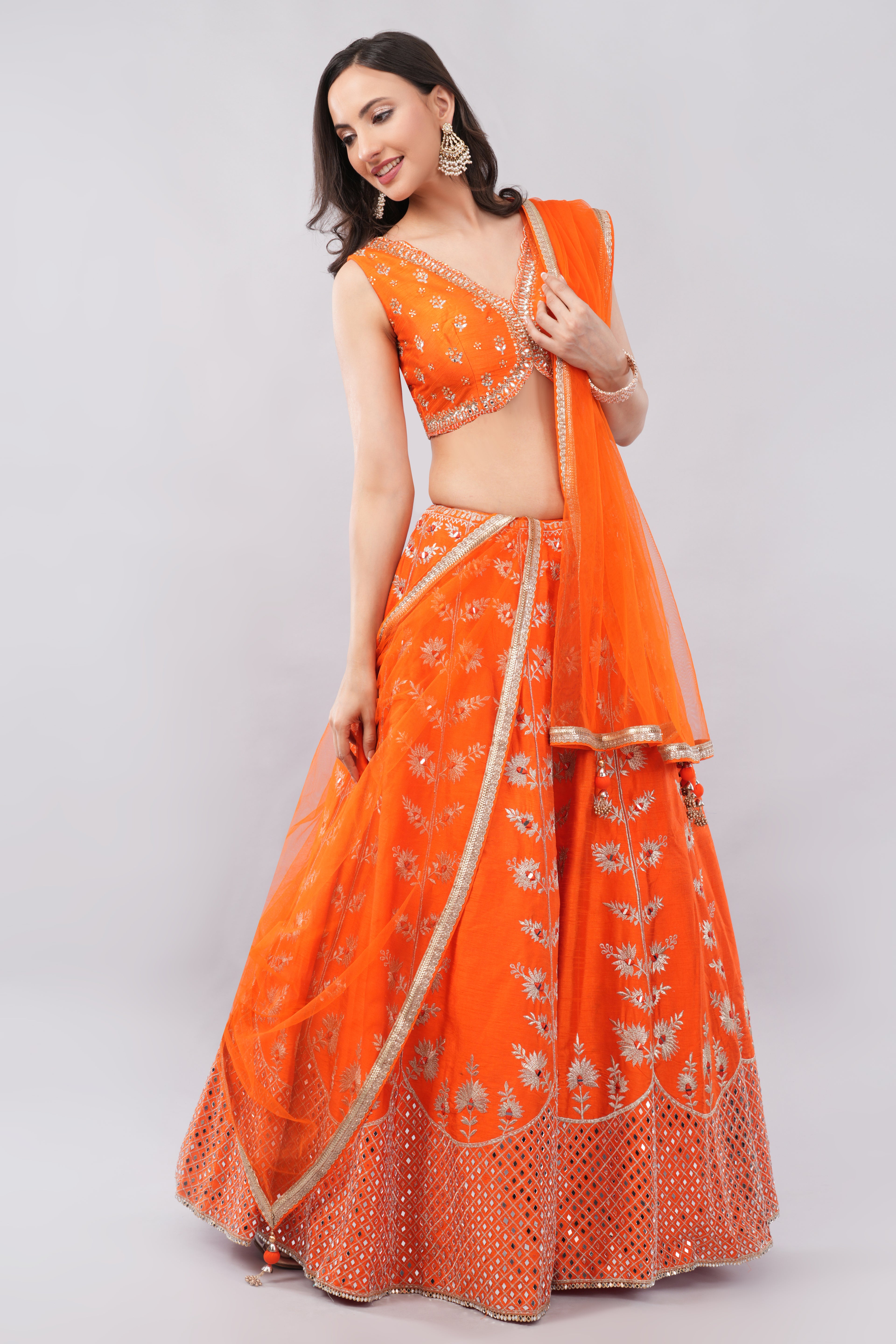 Rust orange raw silk embellished Lehenga choli.